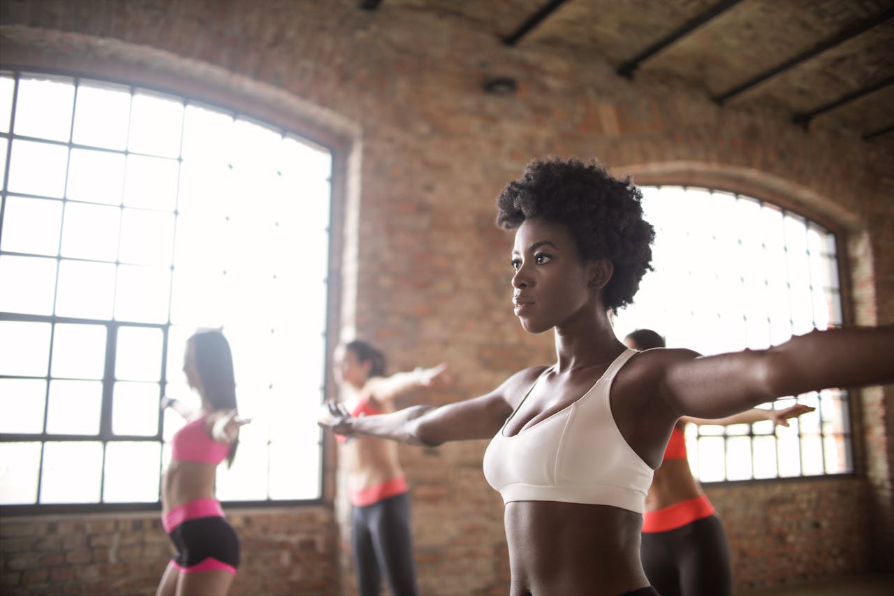 Femmes bras tendus en cours de fitness dans un loft aux murs de briques